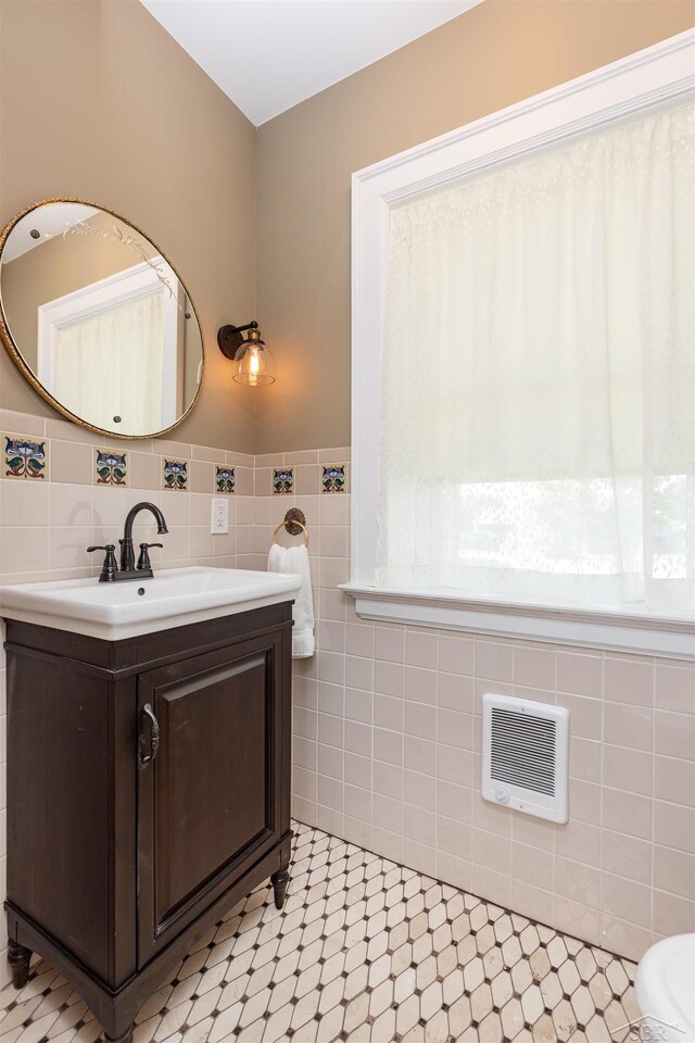 820 N Johnson St, Bay City, MI 48708 - bathroom with vanity, tile walls, heating unit, and tile patterned floors
