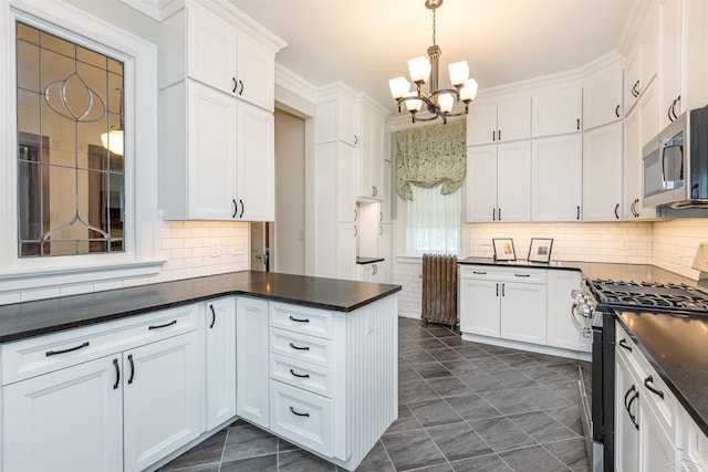 820 N Johnson St, Bay City, MI 48708 - kitchen featuring appliances with stainless steel finishes, dark countertops, a chandelier, white cabinets, and crown molding