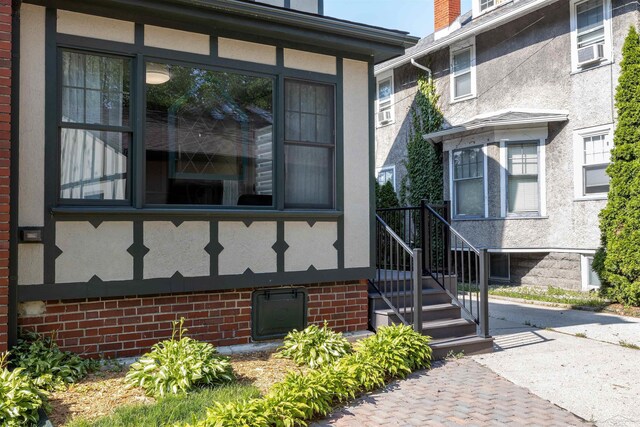 820 N Johnson St, Bay City, MI 48708 - doorway to property with stucco siding and cooling unit