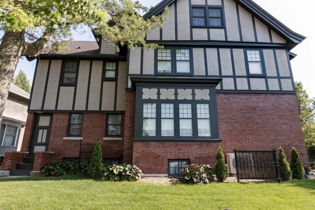 820 N Johnson St, Bay City, MI 48708 - rear view of property with stucco siding, brick siding, and a lawn