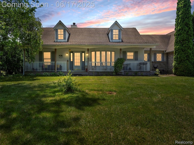 2520 Chilson Meadows Ln, Howell, MI 48843 - view of front facade with covered porch, a chimney, a lawn, and board and batten siding