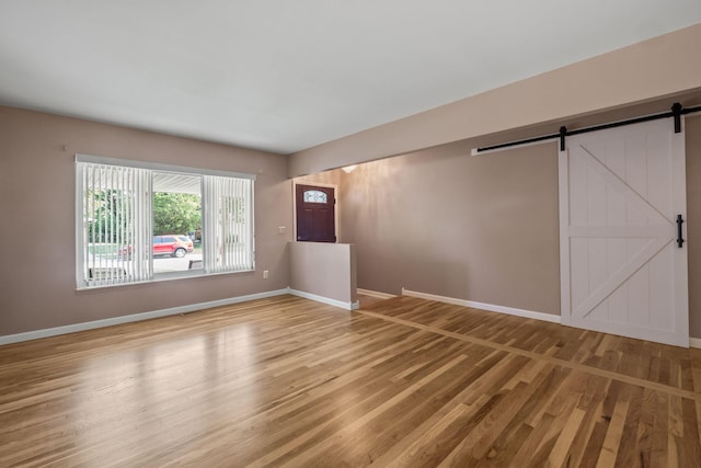 2850 Sherbourne Dr, Troy, MI 48083 - empty room featuring a barn door and light wood finished floors