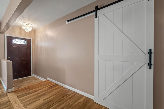 2850 Sherbourne Dr, Troy, MI 48083 - foyer with a barn door, light wood-style flooring, and a chandelier