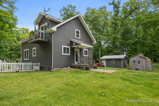 5980 Division St, Newaygo, MI 49337 - rear view of house with a balcony, a storage shed, a yard, and view of wooded area