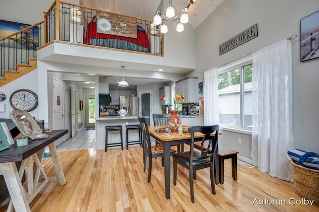5980 Division St, Newaygo, MI 49337 - dining space with high vaulted ceiling, stairs, light wood-style floors, a chandelier, and wood ceiling