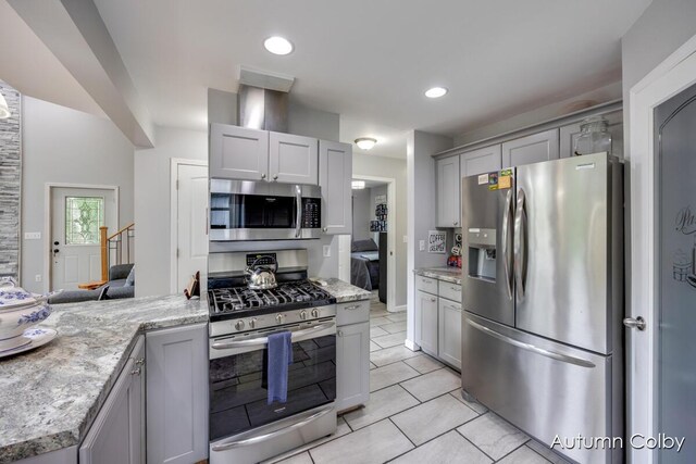 5980 Division St, Newaygo, MI 49337 - kitchen featuring appliances with stainless steel finishes, gray cabinets, light tile patterned floors, light stone counters, and recessed lighting