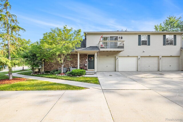 4022 Stonebridge, Holly, MI 48442 - multi unit property with a balcony, driveway, an attached garage, and brick siding