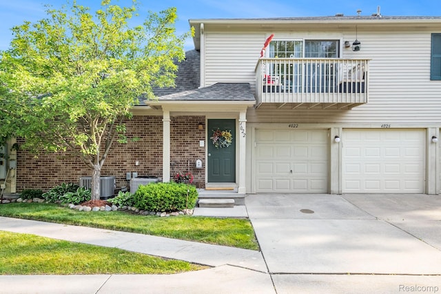 4022 Stonebridge, Holly, MI 48442 - view of front facade featuring a balcony, driveway, brick siding, a garage, and roof with shingles