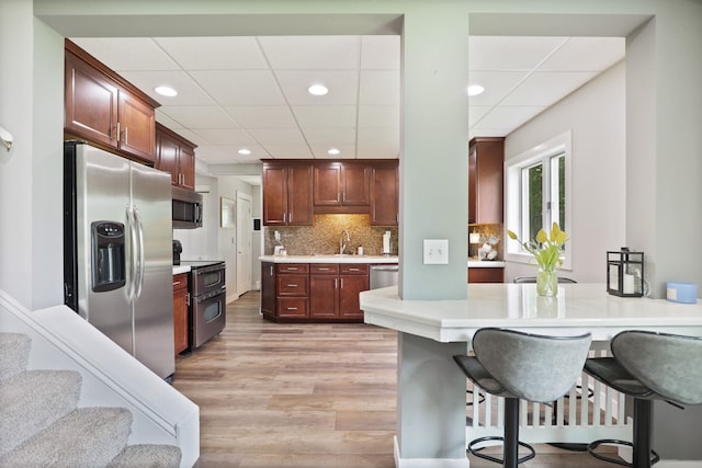 1105 W Genesee St, Frankenmuth, MI 48734 - kitchen with stainless steel appliances, light wood finished floors, light countertops, recessed lighting, and a kitchen bar