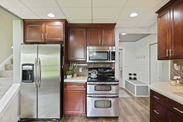 1105 W Genesee St, Frankenmuth, MI 48734 - kitchen featuring stainless steel appliances, tasteful backsplash, light wood finished floors, light countertops, and a paneled ceiling