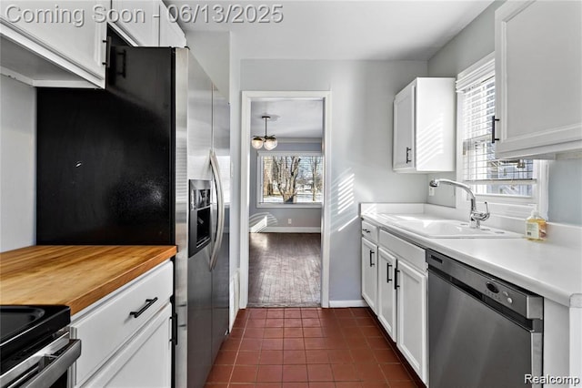 4033 Oakshire Ave, Berkley, MI 48072 - kitchen with appliances with stainless steel finishes, white cabinets, butcher block countertops, and dark tile patterned flooring
