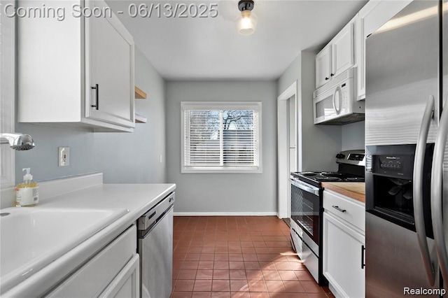 4033 Oakshire Ave, Berkley, MI 48072 - kitchen with stainless steel appliances, light countertops, white cabinets, and dark tile patterned floors