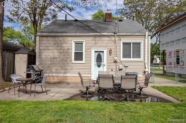 4033 Oakshire Ave, Berkley, MI 48072 - rear view of property featuring a storage unit, a chimney, a patio area, and roof with shingles