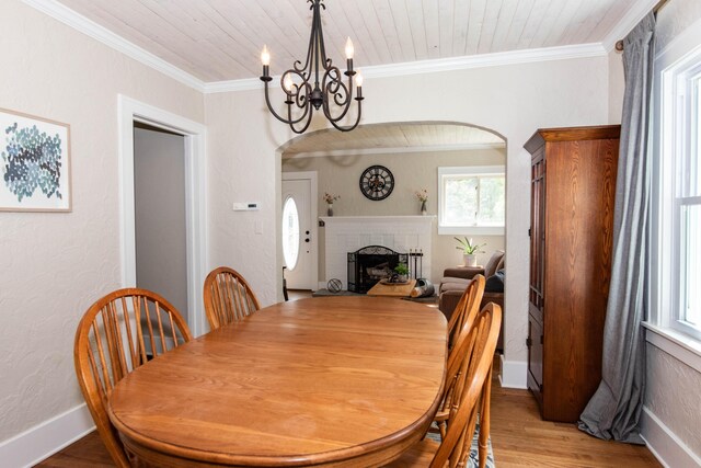 1303 Homecrest Ave, Kalamazoo, MI 49001 - dining space with plenty of natural light, a chandelier, a fireplace, light wood-type flooring, and ornamental molding