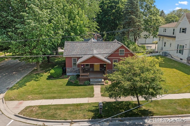 340 E Main St SE, Caledonia, MI 49316 - view of front of property featuring covered porch, stone siding, a front yard, and a chimney