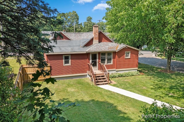 340 E Main St SE, Caledonia, MI 49316 - view of front facade with a front lawn, a chimney, and a shingled roof