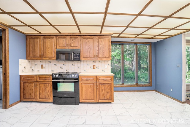 6555 Waybridge Dr SE, Grand Rapids, MI 49546 - kitchen with black appliances, light marble finish flooring, brown cabinetry, and light countertops