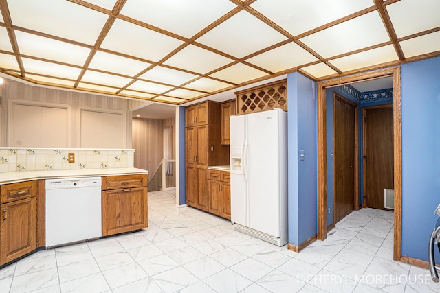 6555 Waybridge Dr SE, Grand Rapids, MI 49546 - kitchen with white appliances, brown cabinetry, light countertops, light marble finish floors, and decorative backsplash