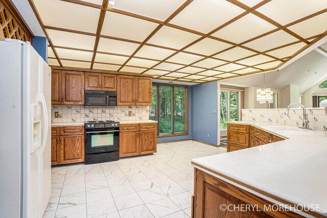 6555 Waybridge Dr SE, Grand Rapids, MI 49546 - kitchen featuring black appliances, brown cabinets, decorative backsplash, a chandelier, and light marble finish flooring