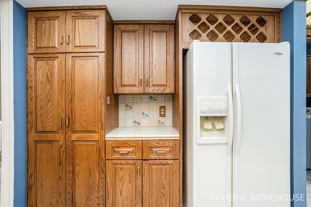6555 Waybridge Dr SE, Grand Rapids, MI 49546 - kitchen with white fridge with ice dispenser, brown cabinets, decorative backsplash, and light countertops