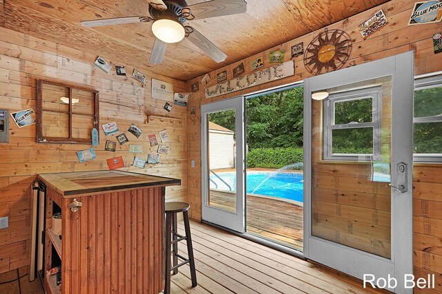 3897 Obrien St SW, Grand Rapids, MI 49534 - doorway to outside featuring wooden walls, light wood-style floors, wooden ceiling, and ceiling fan