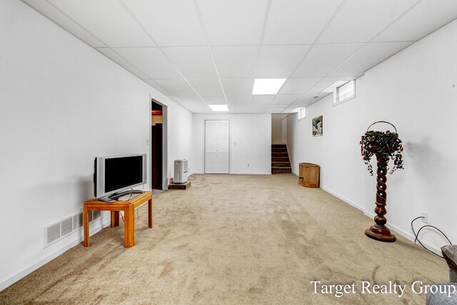 271 Rolling Greene Dr NW, Grand Rapids, MI 49534 - unfurnished living room featuring a paneled ceiling, stairway, and carpet flooring
