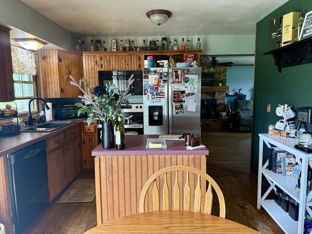 15030 N A Dr N, Marshall, MI 49068 - kitchen with black microwave, dishwashing machine, stainless steel fridge, dark wood-style flooring, and a fireplace