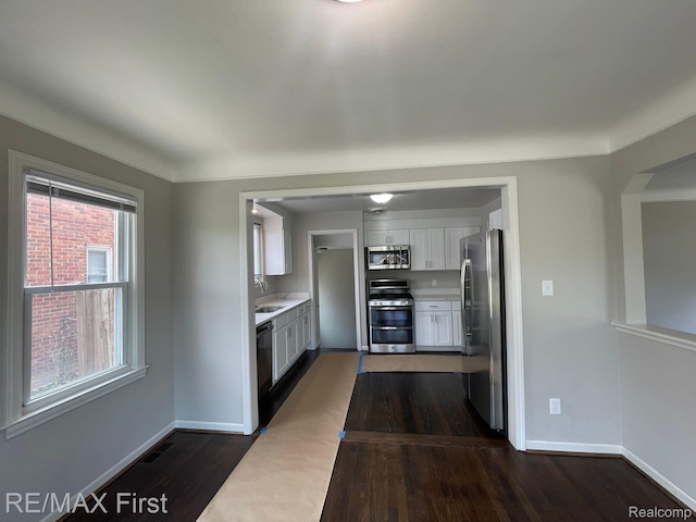 21128 Kenmore Ave, Harper Woods, MI 48225 - kitchen with appliances with stainless steel finishes, white cabinetry, dark wood finished floors, and light countertops