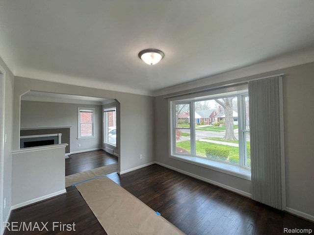 21128 Kenmore Ave, Harper Woods, MI 48225 - unfurnished living room with dark wood finished floors, arched walkways, and a fireplace