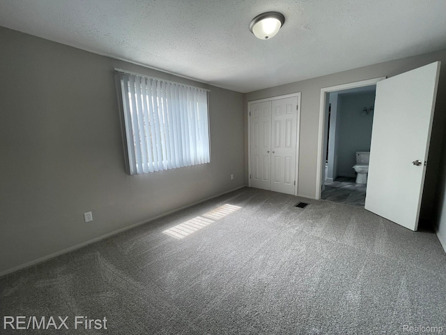 21128 Kenmore Ave, Harper Woods, MI 48225 - unfurnished bedroom featuring carpet, a closet, a textured ceiling, and ensuite bath