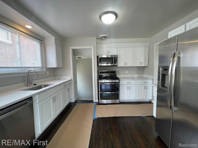 21128 Kenmore Ave, Harper Woods, MI 48225 - kitchen featuring stainless steel appliances, white cabinets, light countertops, and dark wood-style flooring
