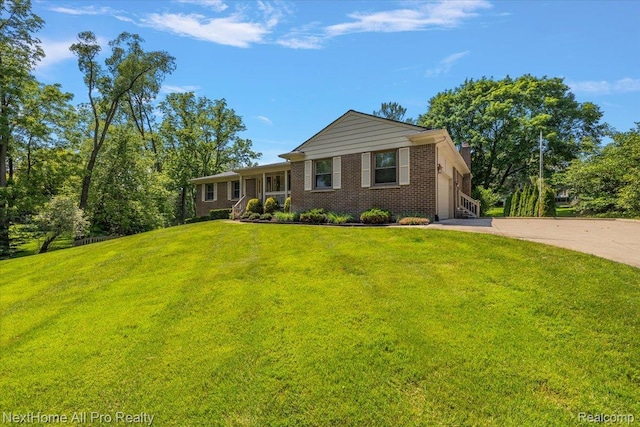 22219 Connemara Dr, Northville, MI 48167 - view of front facade with brick siding, driveway, a front yard, a chimney, and a garage