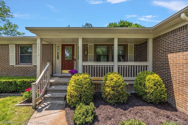 22219 Connemara Dr, Northville, MI 48167 - view of exterior entry with brick siding and a porch