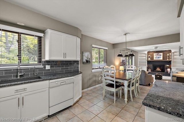 22219 Connemara Dr, Northville, MI 48167 - kitchen with white dishwasher, white cabinets, a fireplace, tasteful backsplash, and open floor plan
