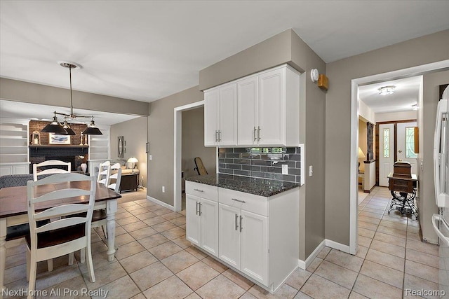 22219 Connemara Dr, Northville, MI 48167 - kitchen with light tile patterned flooring, tasteful backsplash, white cabinets, and dark stone counters