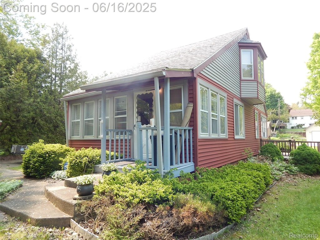 7428 Grove Rd, Lexington, MI 48450 - view of front of property featuring a shingled roof and a porch
