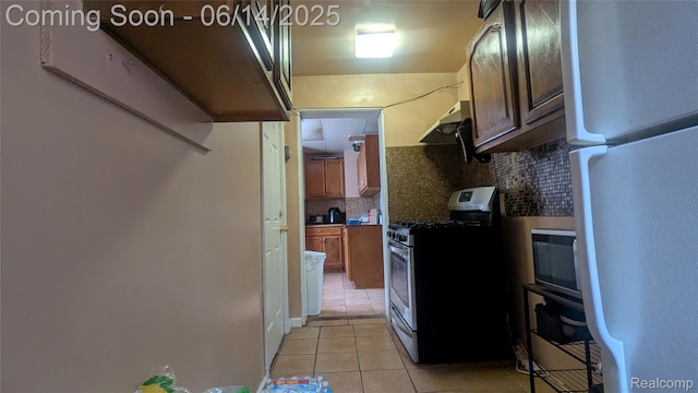 100 Oliver St, Pontiac, MI 48342 - kitchen featuring freestanding refrigerator, stainless steel gas range, light tile patterned floors, decorative backsplash, and extractor fan