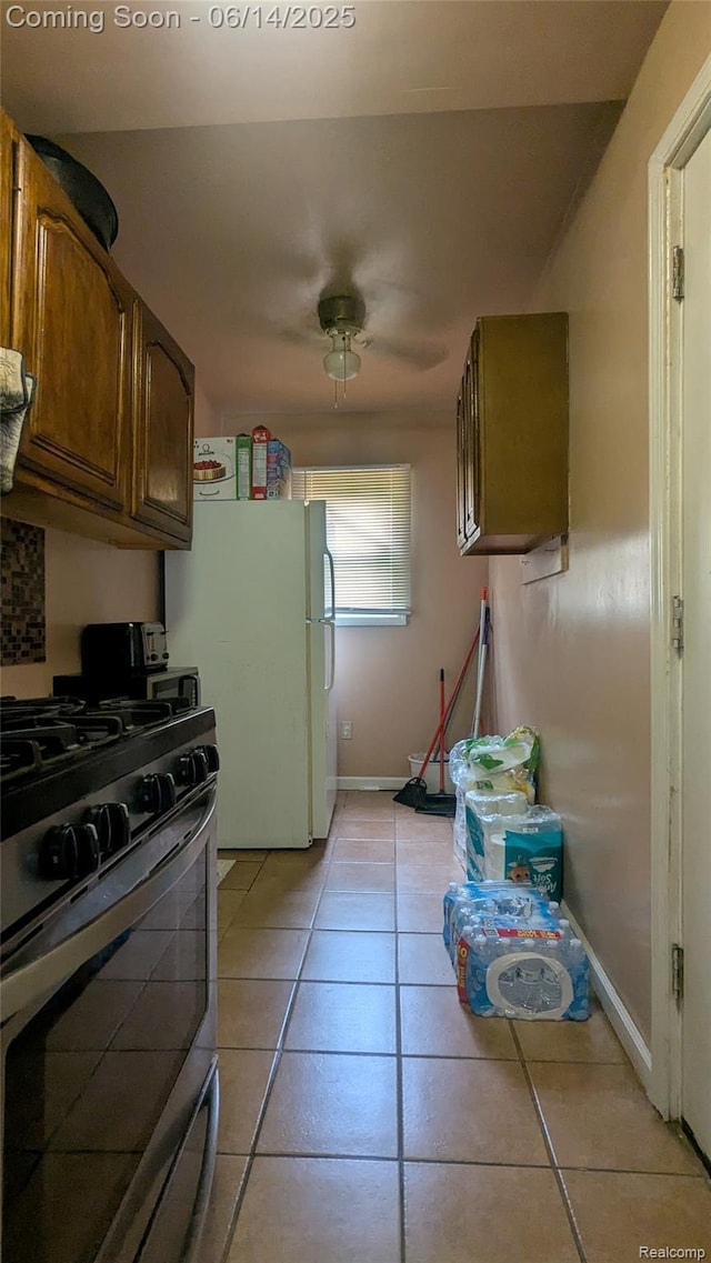 100 Oliver St, Pontiac, MI 48342 - kitchen featuring gas stove, freestanding refrigerator, and light tile patterned flooring