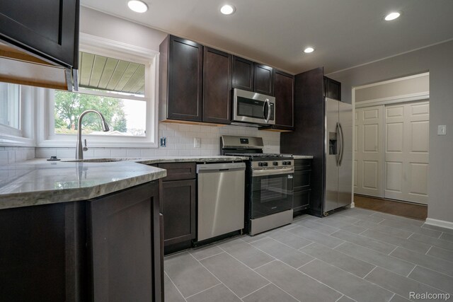 32431 Halmich Dr, Warren, MI 48092 - kitchen featuring stainless steel appliances, backsplash, light stone counters, dark brown cabinets, and recessed lighting