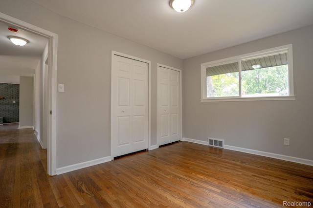 32431 Halmich Dr, Warren, MI 48092 - unfurnished bedroom featuring two closets and wood finished floors