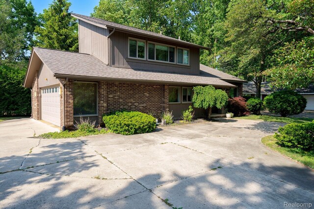 5156 Chestershire Ct, West Bloomfield, MI 48322 - view of front of house with concrete driveway, an attached garage, a shingled roof, and brick siding