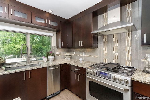 5156 Chestershire Ct, West Bloomfield, MI 48322 - kitchen with wall chimney range hood, stainless steel appliances, decorative backsplash, light stone countertops, and dark brown cabinets