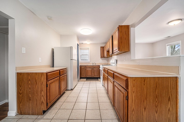 81 Chopin Ave, Troy, MI 48083 - kitchen featuring white appliances, brown cabinets, light countertops, and healthy amount of natural light