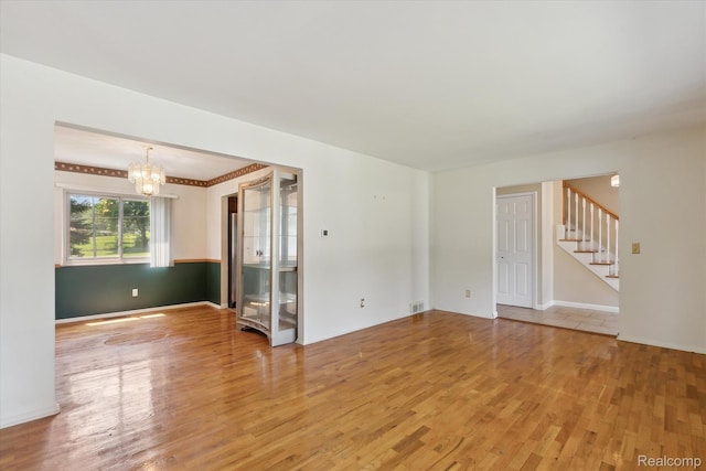 1337 Heathercrest Dr, Flint, MI 48532 - spare room featuring a chandelier, light wood-style floors, and stairway