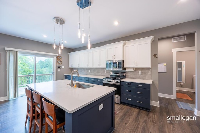6853 Loggers Ridge Run SE, Caledonia, MI 49316 - kitchen featuring appliances with stainless steel finishes, light countertops, backsplash, dark wood finished floors, and white cabinetry