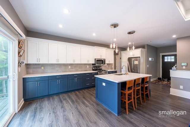 6853 Loggers Ridge Run SE, Caledonia, MI 49316 - kitchen with appliances with stainless steel finishes, blue cabinetry, dark wood-type flooring, a breakfast bar area, and tasteful backsplash