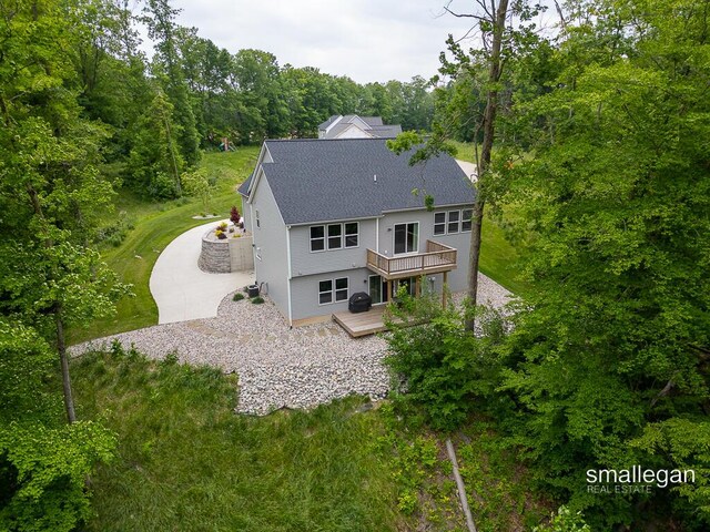 6853 Loggers Ridge Run SE, Caledonia, MI 49316 - rear view of property with a shingled roof, a deck, and a view of trees