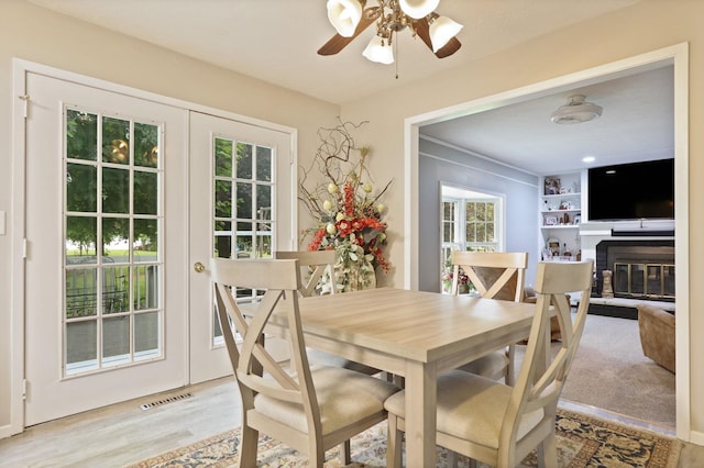 429 Zehnder Dr, Frankenmuth, MI 48734 - dining room featuring a brick fireplace, a ceiling fan, and wood finished floors
