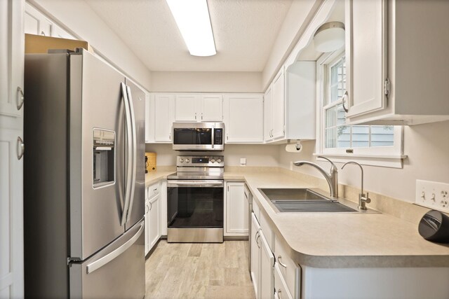 429 Zehnder Dr, Frankenmuth, MI 48734 - kitchen with stainless steel appliances, light wood-style flooring, light countertops, and white cabinetry