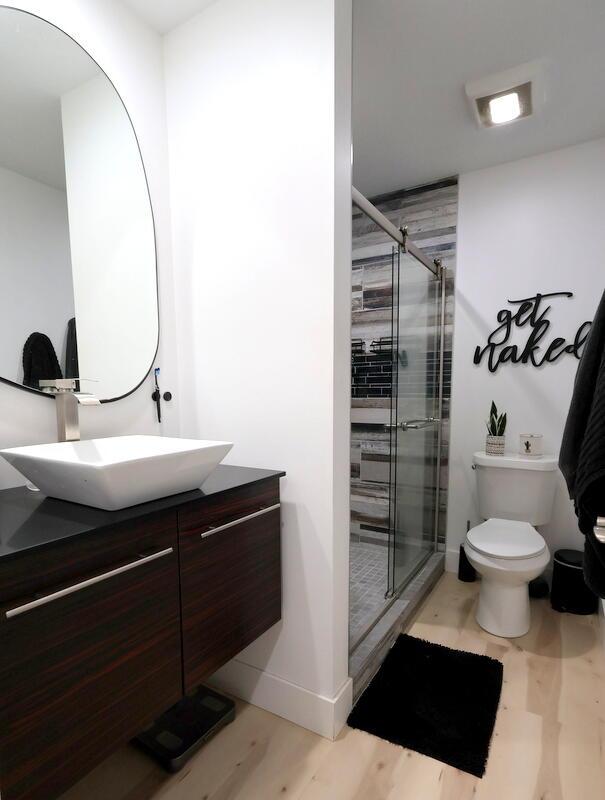 103 Cottonwood Ct, Litchfield, MI 49252 - full bathroom featuring vanity, a stall shower, and wood finished floors